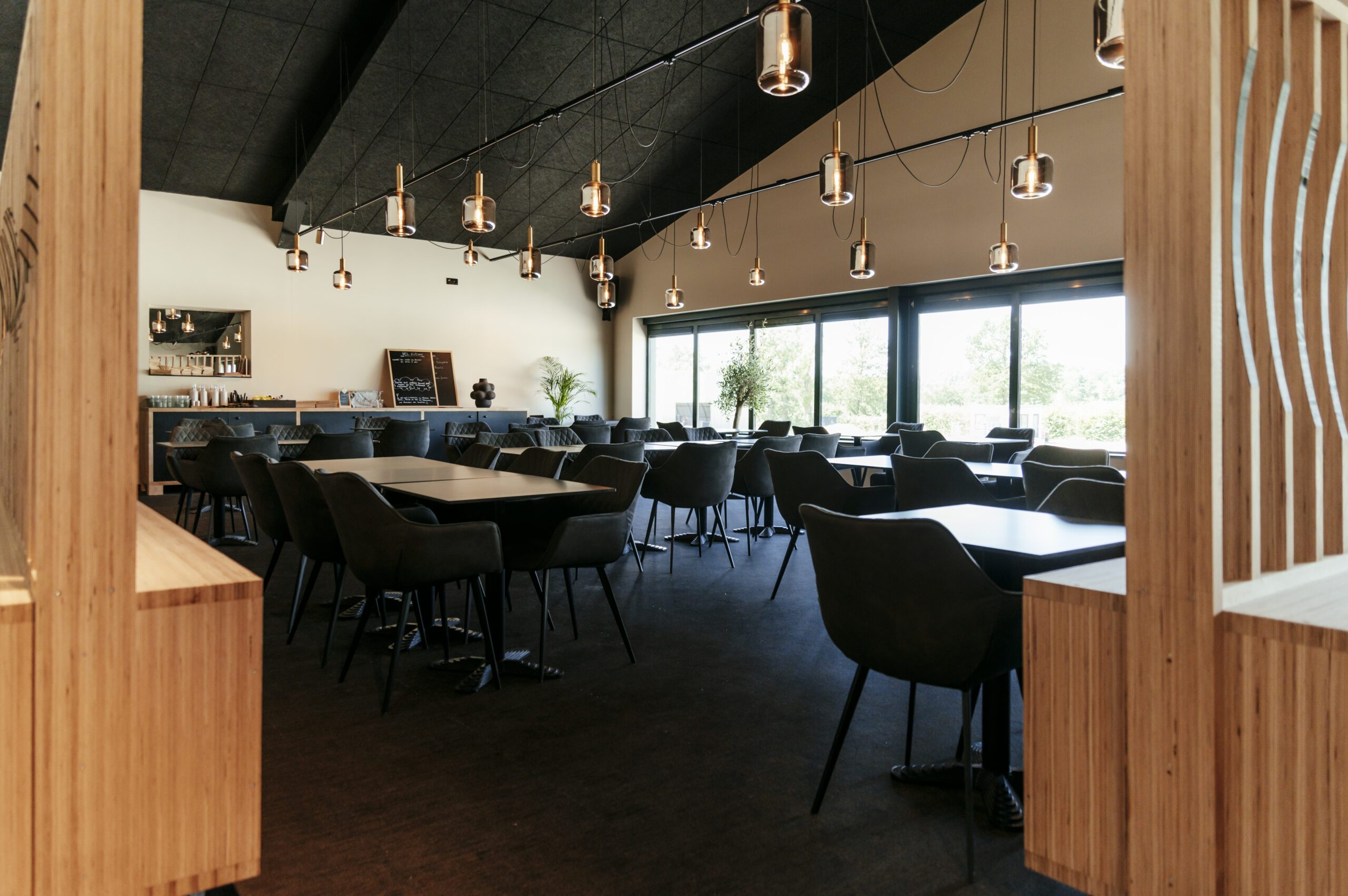 La salle du restaurant du Wel Padel, tables et claustra en bois