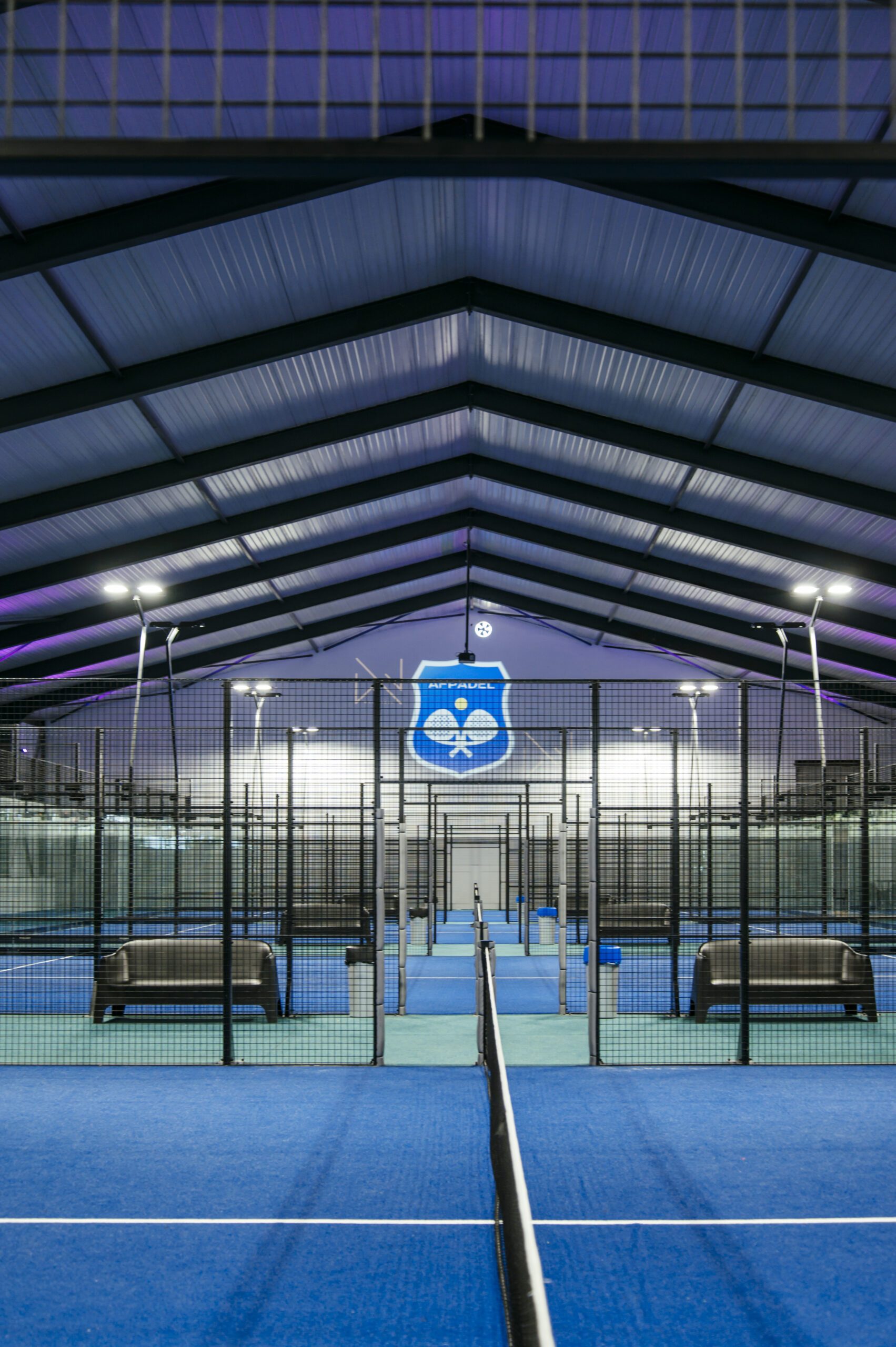 Un terrain de padel du Wel Padel, logo du club sur la vitre de fond